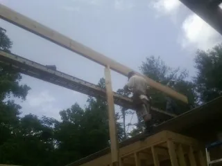 Carpenter setting a ridge beam over a new addition frame — Ice Dam Removal by Roofing Brothers in Middletown